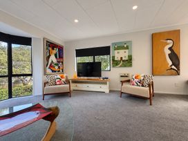 A living room with a TV and artwork at Gallery Grove - New Plymouth Holiday Home, New Plymouth