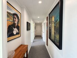 A hallway with paintings on the walls and a table at Gallery Grove - New Plymouth Holiday Home, New Plymouth