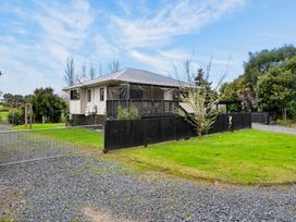 A house with a deck and garden at Surf House - Mangawhai Heads Holiday Home Mangawhai Heads