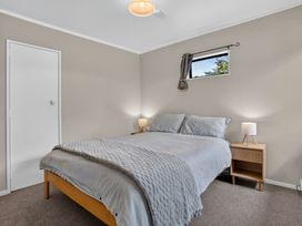 A bedroom with a bed and nightstand at Surf House - Mangawhai Heads Holiday Home Mangawhai Heads