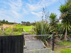 A garden with a gate and plants at Surf House - Mangawhai Heads Holiday Home Mangawhai Heads