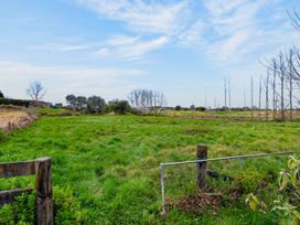 A field with grass and trees at Surf House - Mangawhai Heads Holiday Home Mangawhai Heads