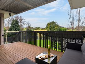 A deck with a view and furniture at Surf House - Mangawhai Heads Holiday Home Mangawhai Heads