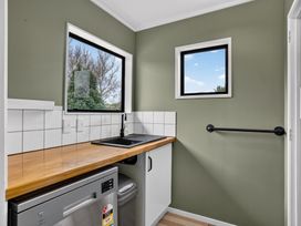 A laundry room with a sink and washing machine at Surf House - Mangawhai Heads Holiday Home, Mangawhai Heads