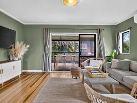 A living room with a sofa and television at Surf House - Mangawhai Heads Holiday Home Mangawhai Heads