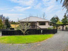 A house with a fence and trees at Surf House - Mangawhai Heads Holiday Home Mangawhai Heads