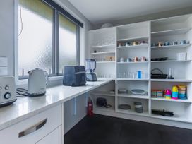 A kitchen with appliances and shelves at Natives Nest - Karikari Peninsula Holiday Home, Karikari Peninsula
