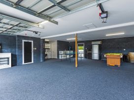 A garage featuring a washing machine, refrigerator, pool table, and table at Natives Nest - Karikari Peninsula
