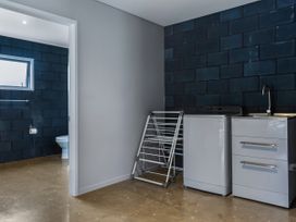 A laundry room with a washing machine and sink at Natives Nest - Karikari Peninsula