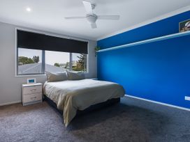 A bedroom with a bed and nightstand at Natives Nest - Karikari Peninsula