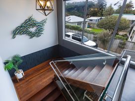 A staircase with a plant and wall art at Natives Nest - Karikari Peninsula Holiday Home Karikari Peninsula