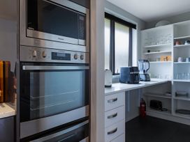 A kitchen with appliances and glassware at Natives Nest - Karikari Peninsula