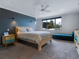 A bedroom with a bed and nightstand at Natives Nest - Karikari Peninsula