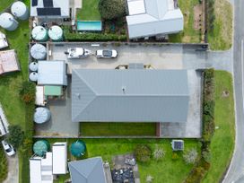 An aerial view of a house with a garage and parked car at Natives Nest - Karikari Peninsula Holiday Home, Karikari Peninsula