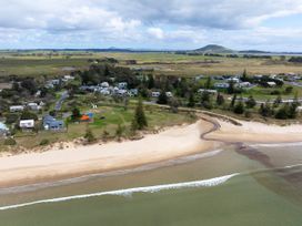 An aerial view of a beach with houses and hills at Natives Nest - Karikari Peninsula Holiday Home Karikari Peninsula