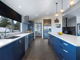A kitchen featuring cabinets, sink, refrigerator, and cooking utensils at Natives Nest - Karikari Peninsula
