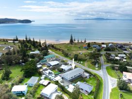 An aerial view of the coast with houses near the ocean at Natives Nest - Karikari Peninsula