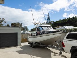 A boat on a trailer parked next to a garage at Natives Nest - Karikari Peninsula