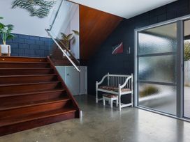 An entrance hall with stairs and a bench at Natives Nest - Karikari Peninsula