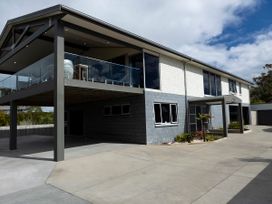 A house with a balcony and driveway at Natives Nest - Karikari Peninsula