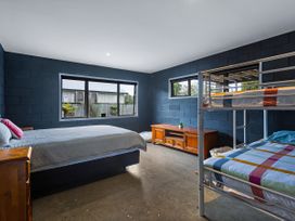 A bedroom with a bed and bunk bed at Natives Nest - Karikari Peninsula