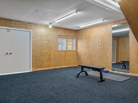 An exercise room with a bench and dumbbells at Helmstead Cottage - Arrowtown