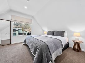 A bedroom with a bed and lamp at Helmstead Cottage - Arrowtown