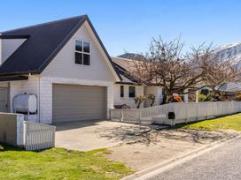 A house with a garage and fence at Helmstead Cottage - Arrowtown Holiday Home, Arrowtown
