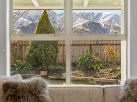 A view of mountains and a garden from a window at Helmstead Cottage - Arrowtown