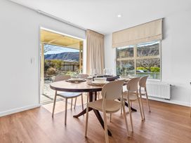 A dining room with a table set for meals at Helmstead Cottage - Arrowtown