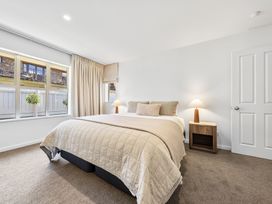 A bedroom with a bed and a nightstand at Helmstead Cottage - Arrowtown