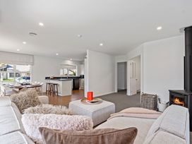 A living room with a stove and dining area at Helmstead Cottage - Arrowtown