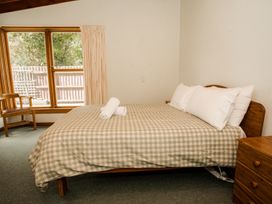 A bedroom with a bed and decorative towels at Little Blue House - Te Anau
