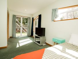 A bedroom with a television and a bed at Little Blue House - Te Anau