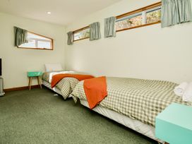 A bedroom with two beds and a nightstand at Little Blue House - Te Anau