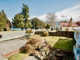 An outdoor scene with trees and a road at Little Blue House - Te Anau