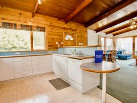 A kitchen with cabinets and a countertop at Little Blue House - Te Anau