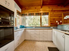 A kitchen with cabinets and appliances at Little Blue House - Te Anau