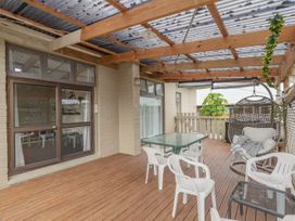 An outdoor deck with a table and chairs at Cozy Family Home - Manukau City