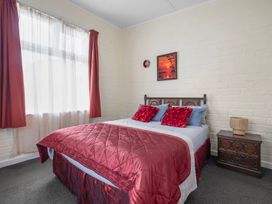 A bedroom with a bed and nightstand at Cozy Family Home - Manukau City Holiday Home, Manukau City