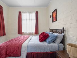 A bedroom with a bed and window at Cozy Family Home - Manukau City