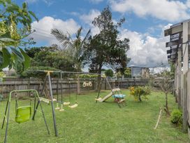 A garden with a swingset and slide at Cozy Family Home - Manukau City Holiday Home, Manukau City