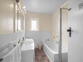 A bathroom with a bathtub and sink at Cozy Family Home - Manukau City