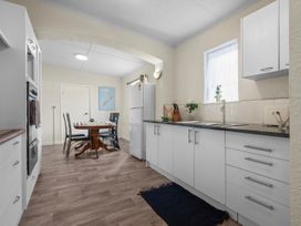 A kitchen with a table and chairs at Cozy Family Home - Manukau City