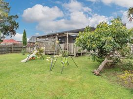 A garden with swing set and slide at Cozy Family Home - Manukau City Holiday Home, Manukau City