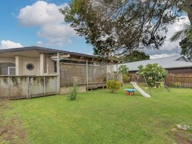 A garden with a swing set and a slide at Cozy Family Home - Manukau City Holiday Home in Manukau City
