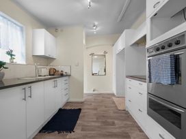 A kitchen with cabinets, a sink, and an oven at Cozy Family Home - Manukau City