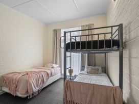 A bedroom with a bunk bed and a single bed at Cozy Family Home - Manukau City