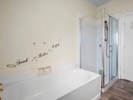 A bathroom with a bathtub and a shower at Cozy Family Home - Manukau City