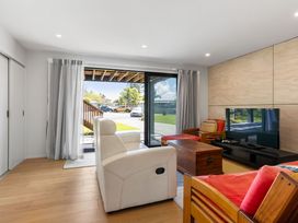 A living room with a tv and coffee table at The Cove Escape - Cooks Beach